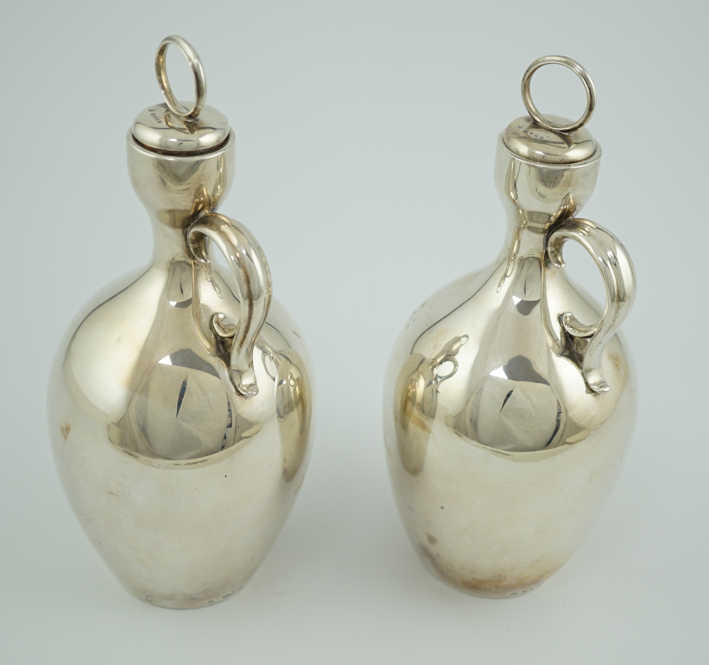 A pair of Victorian silver single handled ovoid water/wine jugs with stoppers, by R & S Garrard & Co